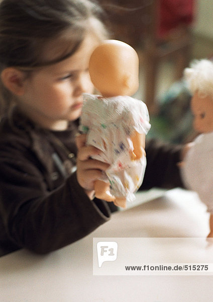 Kind spielt mit Babypuppen