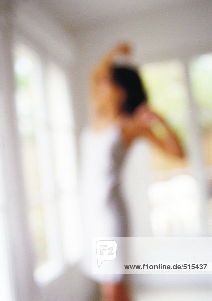 Woman stretching in front of window  blurred.