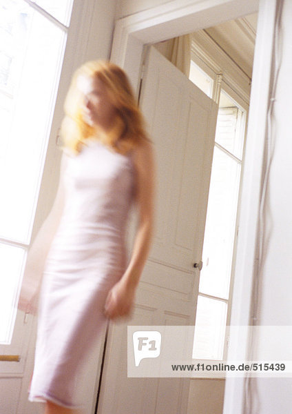 Woman walking through doorway  blurred.