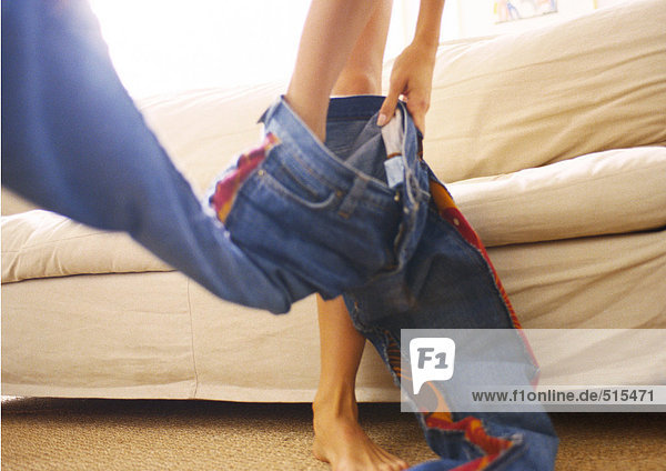 Woman putting pants on  low section  blurred.