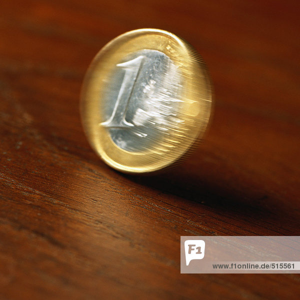 Euro-Münze rollt auf dem Tisch