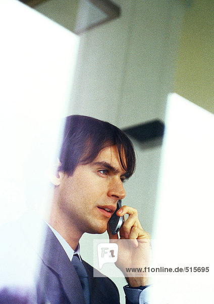 Businessman talking on cell phone  partial view  head and shoulders