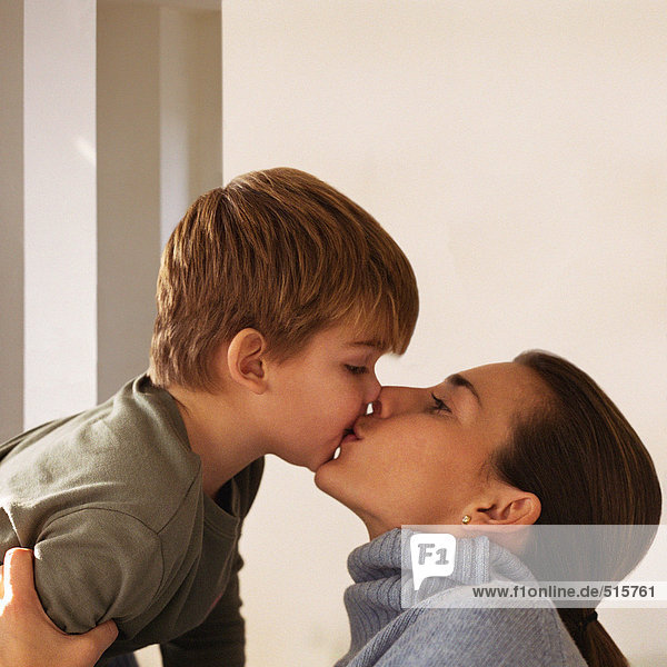 Mother kissing son  head and shoulders  side view
