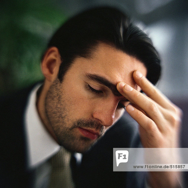 Businessman touching forehead with fingers  portrait