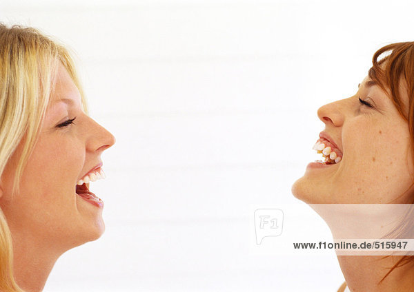 Zwei Frauen  die mit geschlossenen Augen lachen.