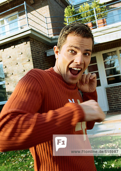 Man standing in front of house  looking surprised
