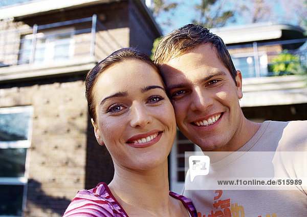 Couple in front of house  smiling  portrait