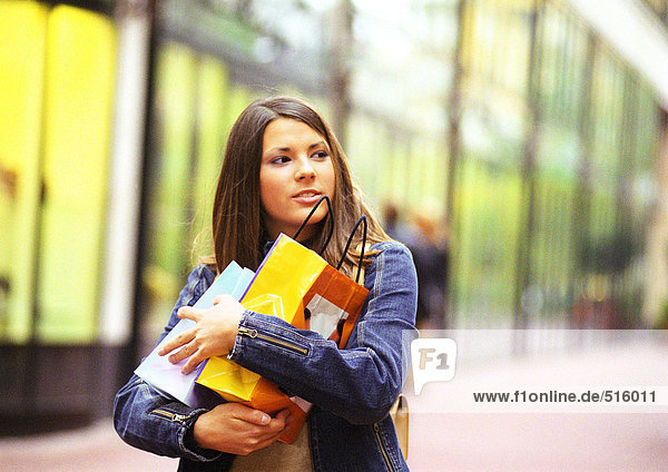 Young woman holding shopping bags in arms