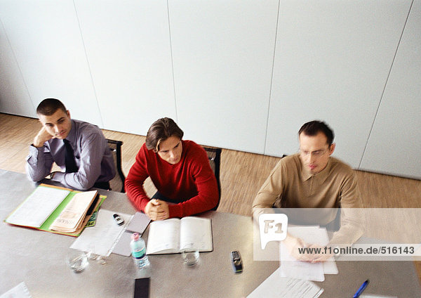 Businessmen sitting at table in office space.