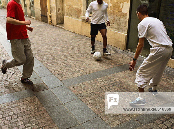 Männer treten Fußball auf der Straße