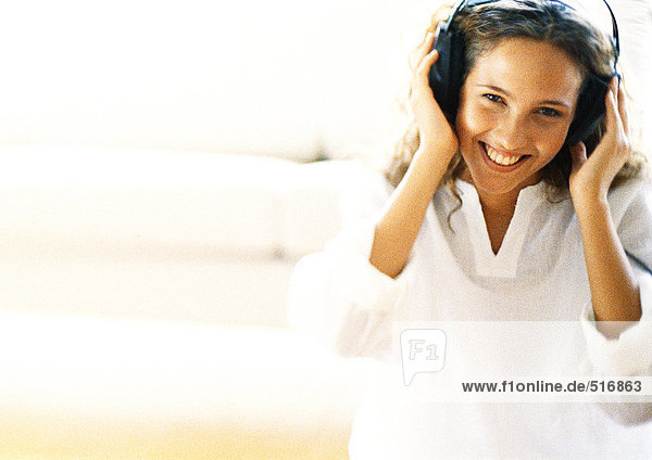 Woman listening to headphones  smiling