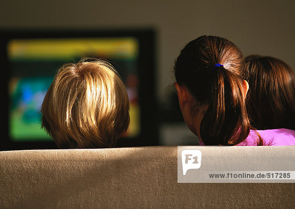 Junge Jungen und Mädchen auf der Couch beim Fernsehen  Rückansicht
