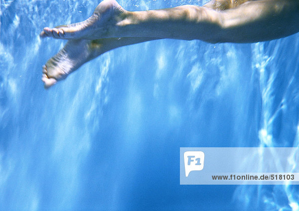 Person  die unter Wasser schwimmt  abgeschnittene Ansicht der Beine