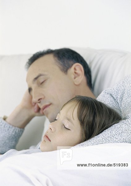 Father and daughter sitting on sofa  sleeping