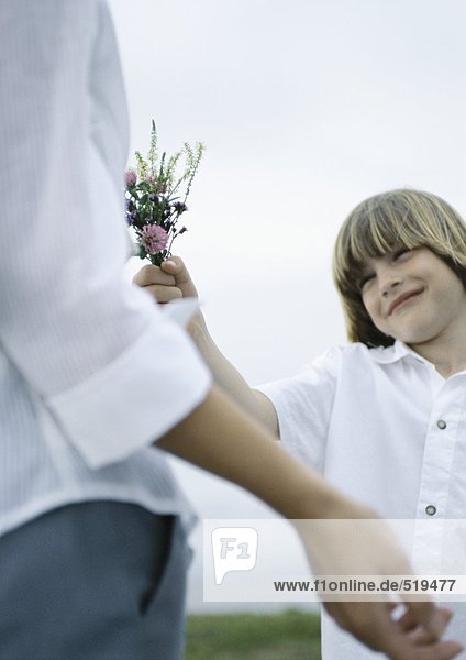 Junge übergebende Frau Blumenstrauß von Wildblumen