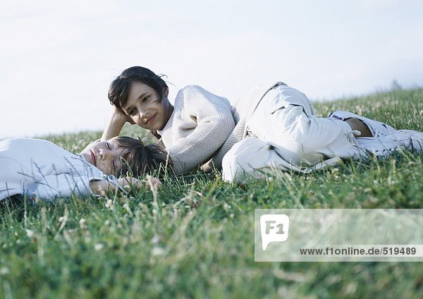 Junge und Mädchen auf Gras liegend