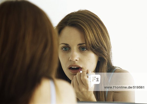 Frau mit Lippenstift im Spiegel