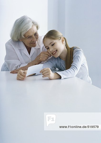 Großmutter und Enkelin beim gemeinsamen Betrachten des Fotos