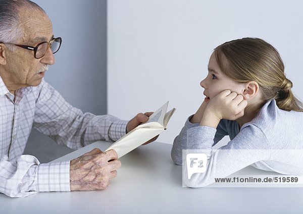 Großvater liest Buch für Enkelin