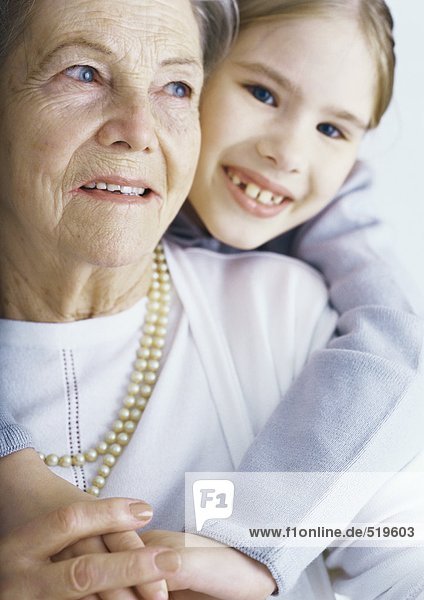 Mädchen umarmt Großmutter  Portrait