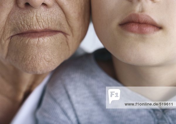 Großmutter und Enkelin Wange an Wange  Nahaufnahme der Münder  Mund
