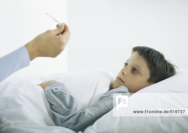 Junge im Bett  Frauenhandthermometer