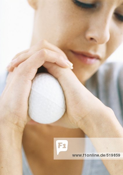 Woman holding stress ball between palms  close-up
