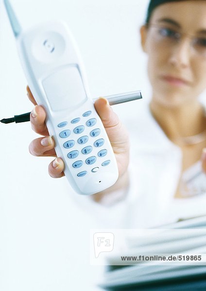 Frau hält schnurloses Telefon aus