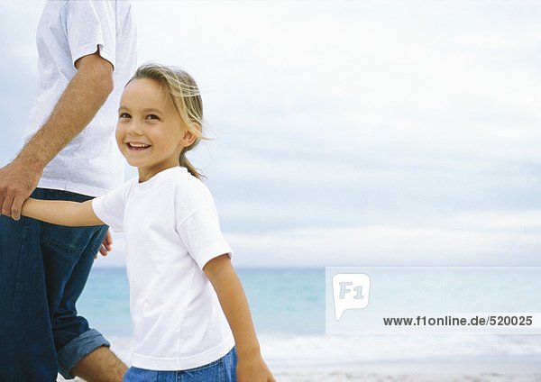 Mädchen beim Spaziergang mit Vater am Strand