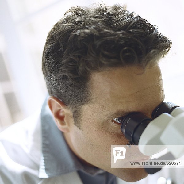 Arzt schaut durchs Mikroskop