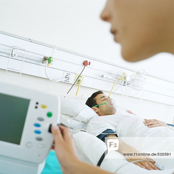 Krankenschwester überprüft Patientenmonitor