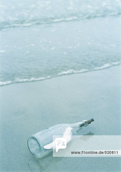 Nachricht in einer Flasche am Strand angespült