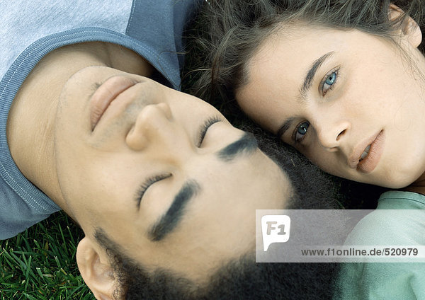 Young couple lying on grass together  close-up
