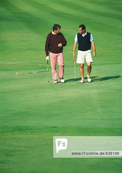 Zwei Golfer zu Fuß auf dem Golfplatz