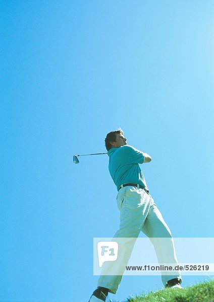 Golfer swinging  low angle view