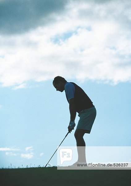 Golfer preparing to swing  backlit