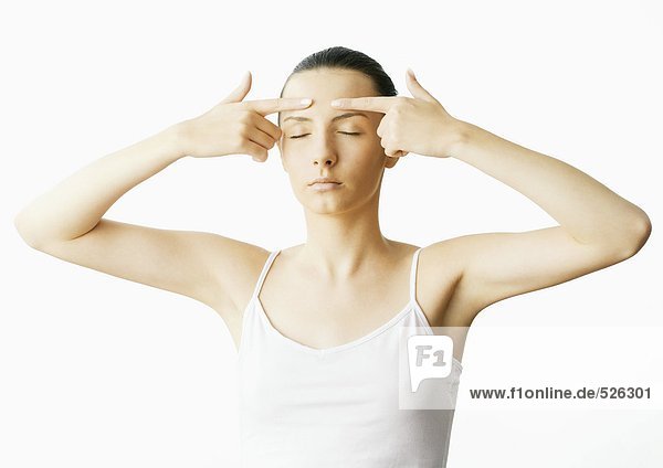 Woman with fingers on forehead and eyes closed