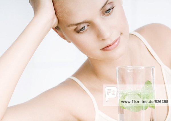 Frau mit einem Glas Kräuterwasser