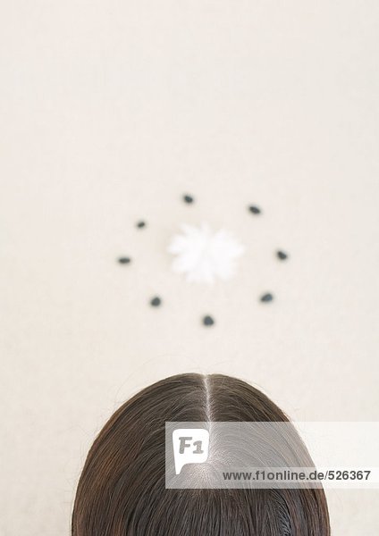 Back of woman's head and flower inside circle