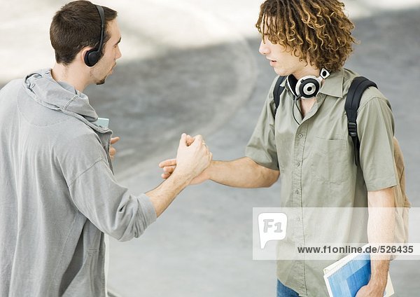 Two young men shaking hands