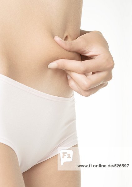 Woman pinching fat on abdomen