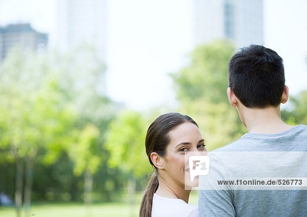 Junges Paar im Stadtpark  Frau schaut dem Mann über die Schulter