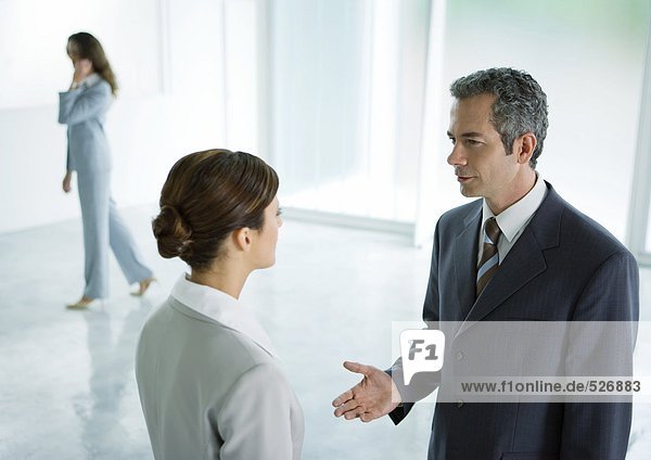 Businessman and businesswoman having discussion in lobby
