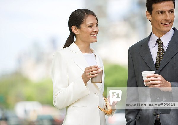 Geschäftsfrau und Mann im Stehen  Kaffee trinken im Freien