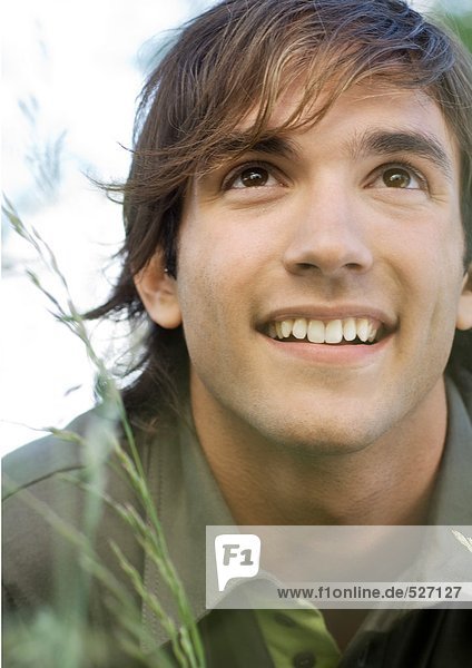 Young man in grass smiling  portrait