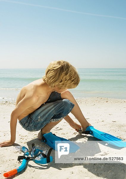 Junge am Strand mit Schwimmflossen