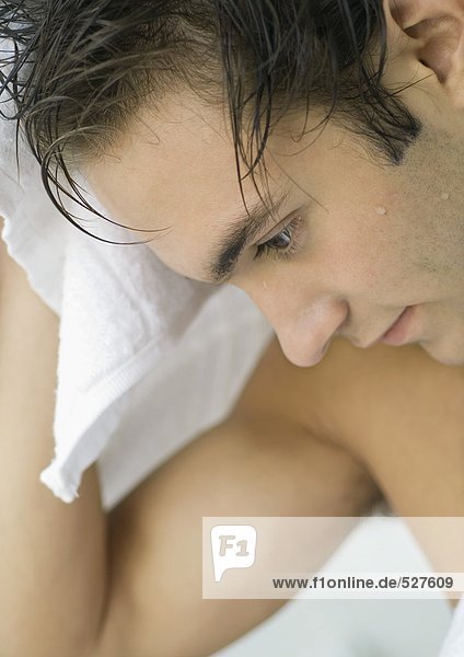 Mann trocknet Haare mit Handtuch