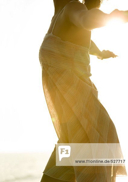 Frau in leichtem Kleid in der Sonne  beschnitten
