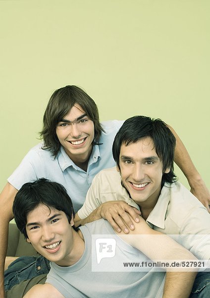 Three young male friends smiling  portrait