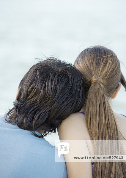 A young man leaning head on girl's shoulder  rear view